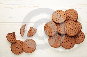 Chocolate chip cookie on white plate on white wooden background. Top view