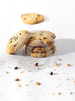 Chocolate chip cookies and crumbs on white background.