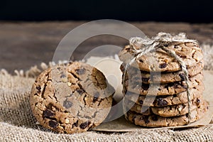 Chocolate chip cookies freshly baked on sackcloth on wooden table background. Homemade pastry. With copy space for text and logo