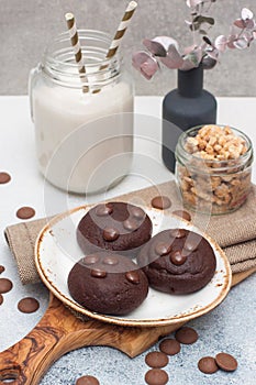 Chocolate chip cookies with glass of milk on gray background