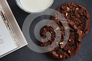 Chocolate chip cookies with a glass of milk on a gray table