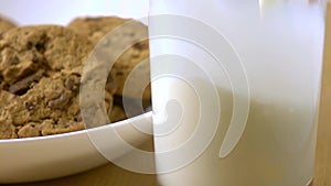 Chocolate chip cookies and milk being poured in a glass. close-up super slow motion shot