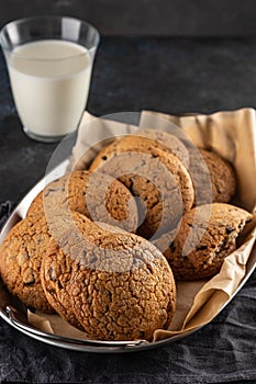 Chocolate chip cookies with milk on black table. Copy space