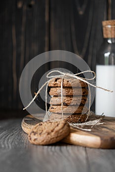 Chocolate chip cookies and milk on wooden background