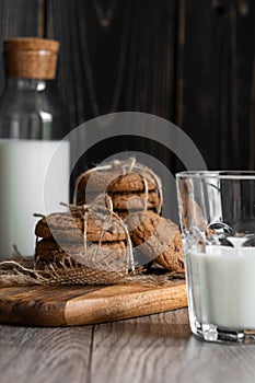 Chocolate chip cookies and milk on wooden background