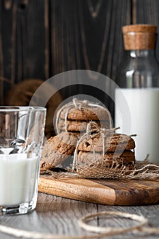 Chocolate chip cookies and milk on wooden background