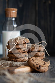 Chocolate chip cookies and milk on wooden background