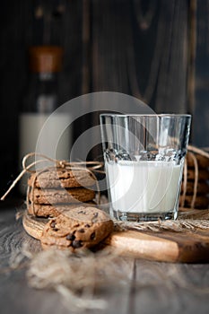 Chocolate chip cookies and milk on wooden background