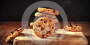 Chocolate chip cookies stack, a panorama on a rustic wooden background