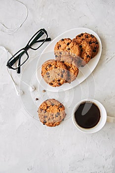 Chocolate chip cookies in a white plate cup of coffee eyeglass