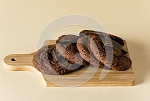 Chocolate Chip Cookies on Wooden Cutting Board Yellow Background Horizontal