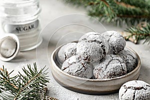 Chocolate chip cracked cookies in ceramic plate on gray textured table backgroun with fir branches decoration. Recipe of