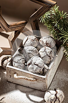 Chocolate chip cracked cookies. Creative art xmas concept with rustic box of chocolate crinkle cookies in icing sugar