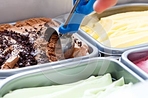 Chocolate chip ice cream being scooped. Surrounded by other flavours photo