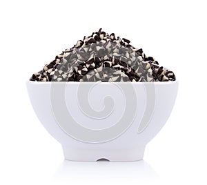 Chocolate chip morsels spread in bowl on white