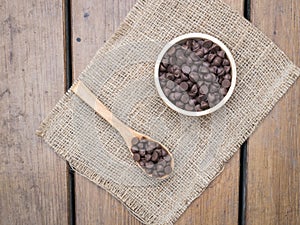 Chocolate chips in wooden spoon and bowl