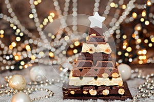 Chocolate Christmas tree in front of booked lights. Selective focus
