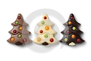 Chocolate christmas trees in a row on white background close up