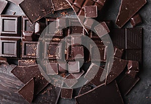 Chocolate chunks. Chocolate bar pieces. A large bar of chocolate on gray abstract background.