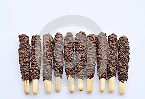 Chocolate coated bread sticks on white background