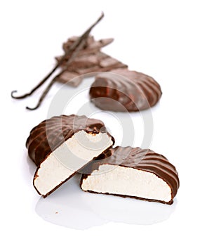 A chocolate-coated zefir with pieces of chocolate and vanilla po