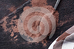 Chocolate cocoa milk powder on a black stone background