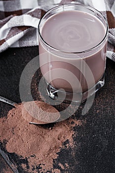 Chocolate cocoa milk powder on a black stone background