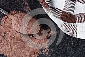 Chocolate cocoa milk powder on a black stone background