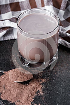 Chocolate cocoa milk powder on a black stone background