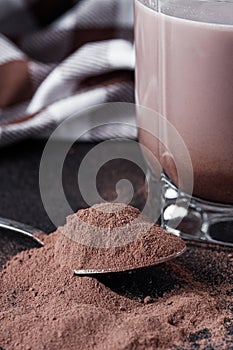 Chocolate cocoa milk powder on a black stone background