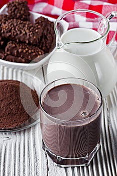 Chocolate cocoa milk powder on a white wooden rustic background