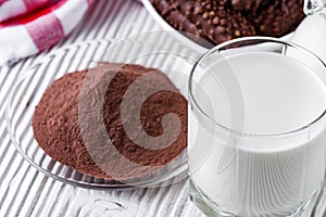 Chocolate cocoa milk powder on a white wooden rustic background