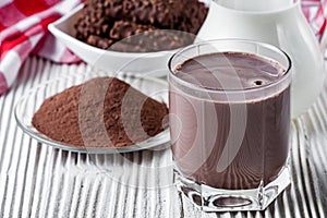 Chocolate cocoa milk powder on a white wooden rustic background