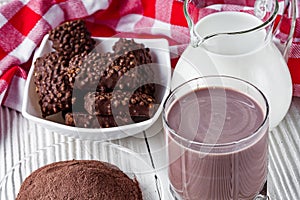 Chocolate cocoa milk powder on a white wooden rustic background