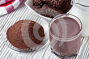 Chocolate cocoa milk powder on a white wooden rustic background