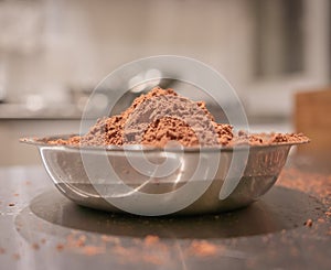 Chocolate cocoa powder in small stainless steel plate.