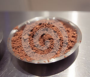 Chocolate cocoa powder in small stainless steel plate.