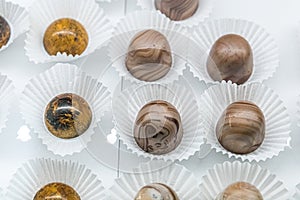A chocolate confectionary and bakery glass display of handmade individual truffles in a variety of colors and flavors