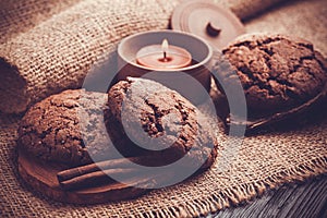 Chocolate cookies with chocolate candle on burlap background