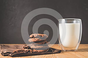 Chocolate cookies and glass of milk on wooden table/Chocolate cookies and glass of milk on wooden table and dark background.