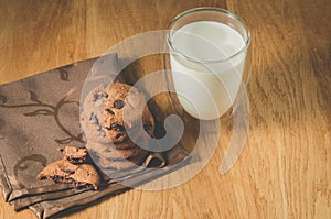 Chocolate cookies and glass of milk on wooden table/Chocolate cookies and glass of milk on wooden table. Selective focus