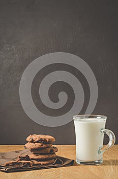 Chocolate cookies and mug glass of milk on wooden table/Chocolate cookies and mug glass of milk on wooden table and dark