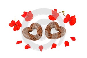 Chocolate cookies in the shape of hearts and bright flowers isolated on white . Valentine`s Day pattern