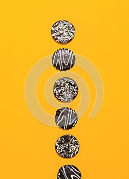 Chocolate cookies on yellow paper background. Minimal art. Holidays time, winter christmas celebration, diet, calorie, sweet shop
