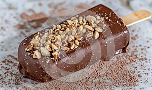 Chocolate-covered nut bar with sprinkled toppings photo