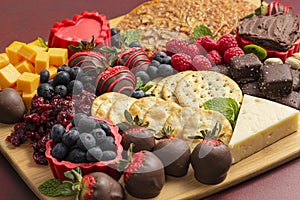 A Chocolate Covered Strawberries and Cheese Sweet Charcuterie Board on a Red Table