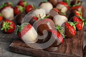Chocolate covered strawberries on wooden board photo