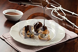 Chocolate cream and cocoa profiteroles with hot melted dripping topping