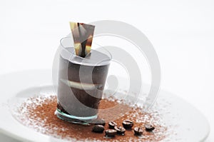 Chocolate cream in taster, chocolate desert on white plate with coffee beans and cocoa powder, patisserie, photography for shop