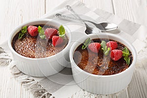 Chocolate creme brulee dessert consisting of a rich custard base topped with a layer of hardened caramelized sugar close-up in a